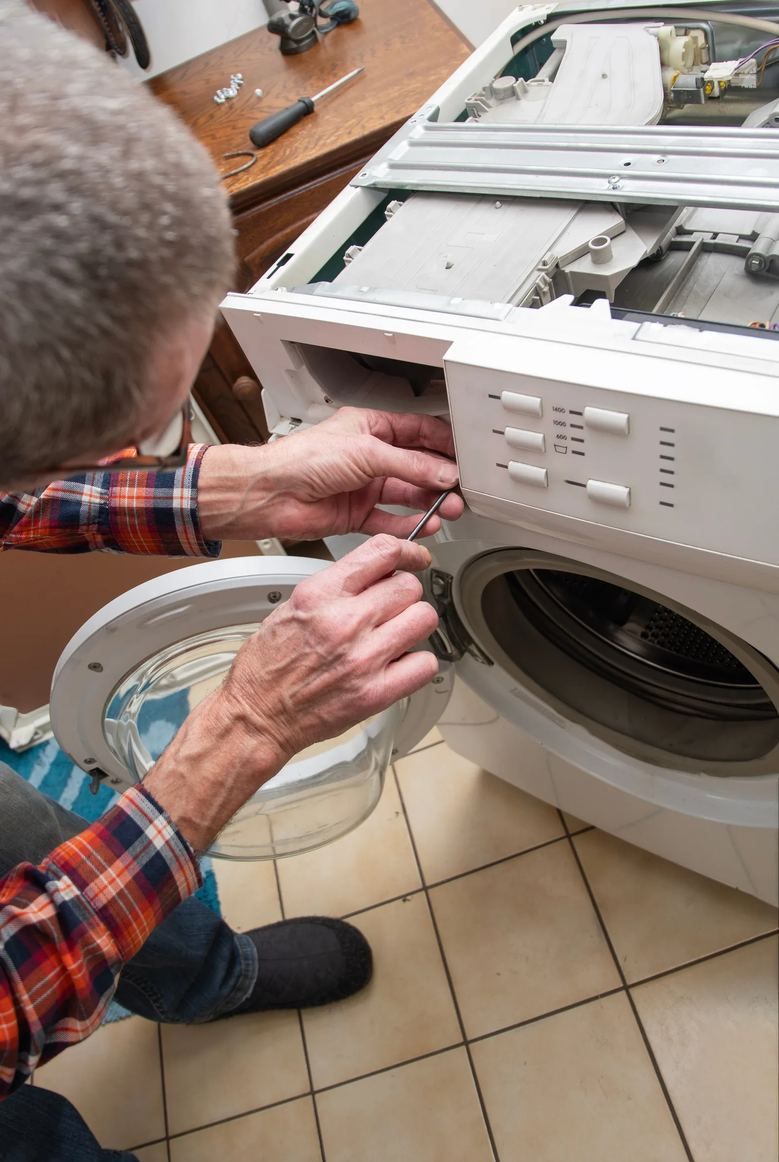 Technician repairing the top of a washing machine on-site